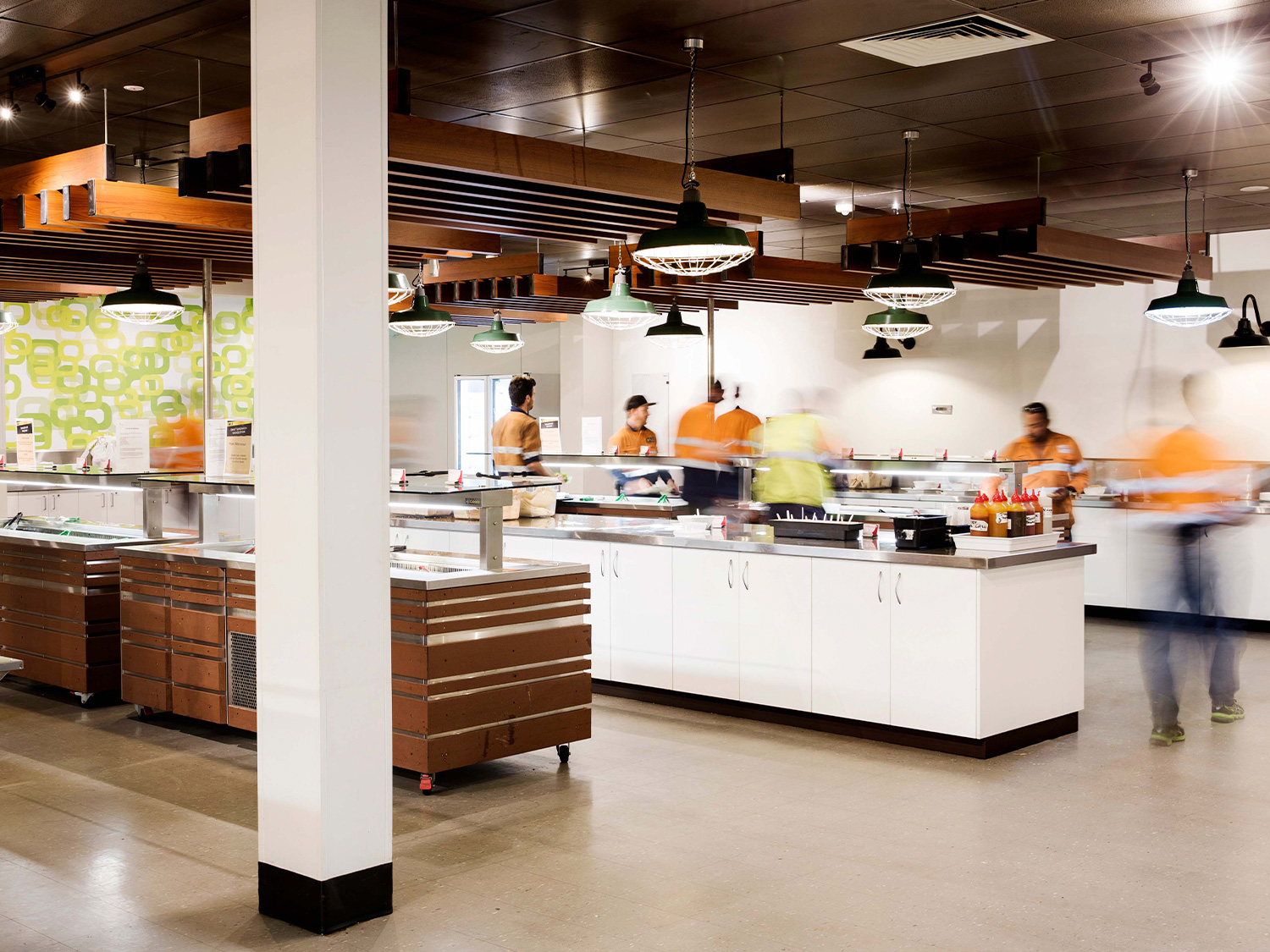 Modern buffet serving line with workers wearing bright safety vests