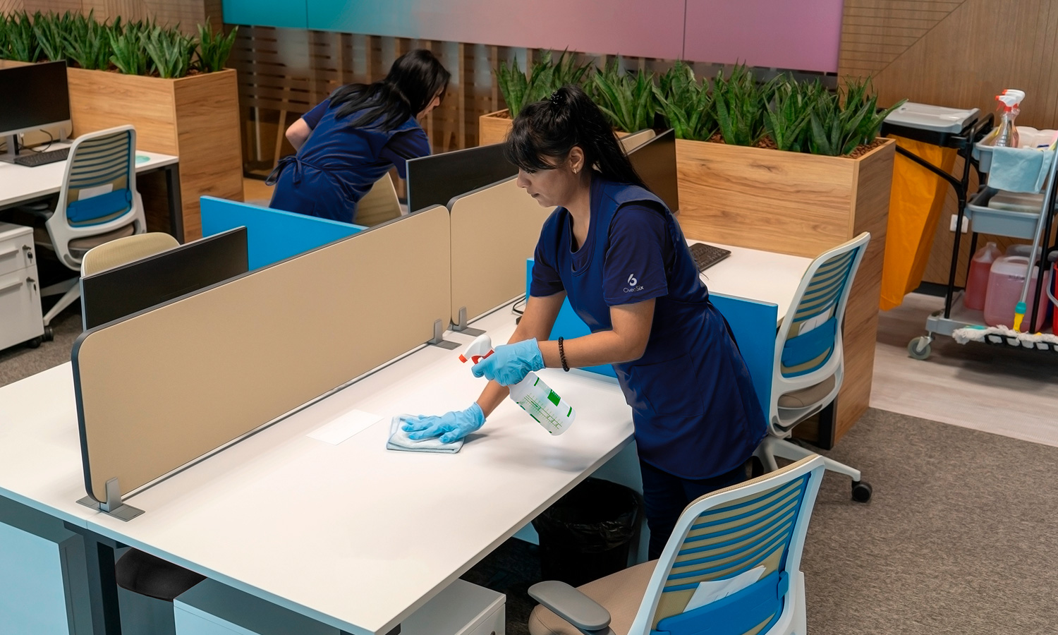 Employee cleaning a desk in an open office