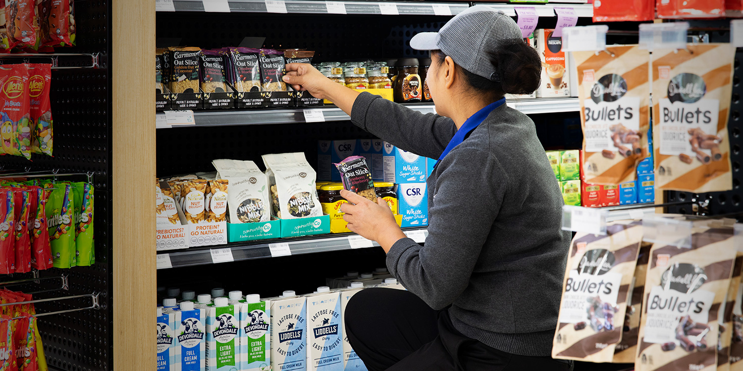 Employee stocking shelves with snacks